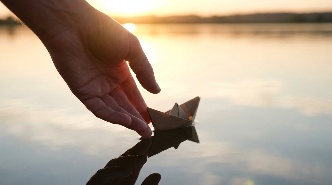 pustanje opsesivnih misli okp rjesenje Ruka pušta papirnati brodić na mirnu vodenu površinu — simbolizira puštanje opsesivnih misli i pronalazak unutarnjeg mira kroz hipnoterapiju